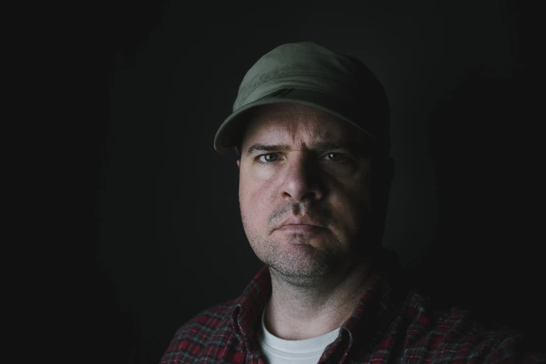 a man wearing a hat in a dark room