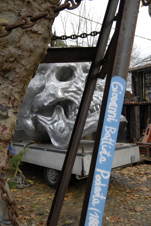 this is an odd silver mask sculpture that was placed outside a barn