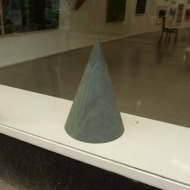 a cone is on display in front of a glass door