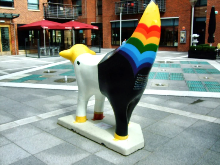 a plastic cow has a colorful rainbow painted tail