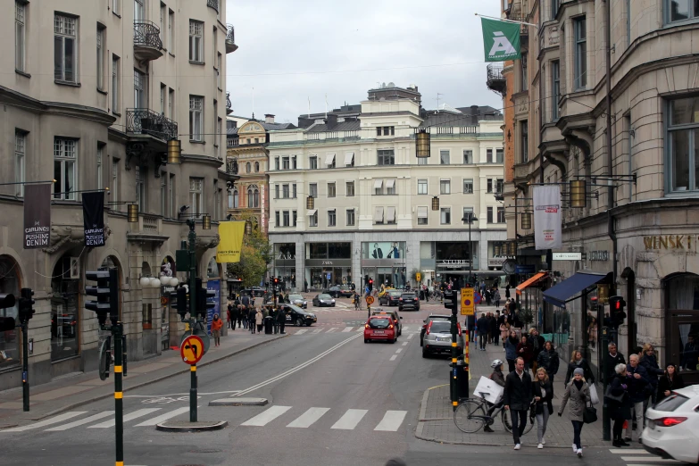 a group of people walk through a city with tall buildings