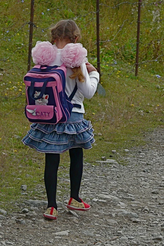 a little girl in boots and with her backpack