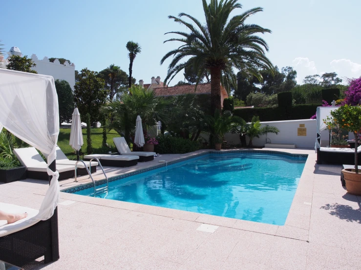 a pool in a backyard near an outdoor seating area