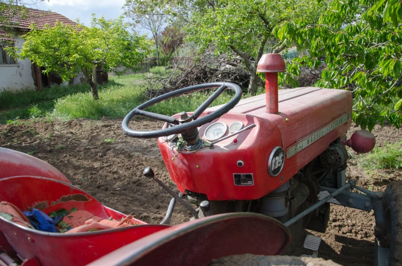 an older tractor sits parked in the dirt