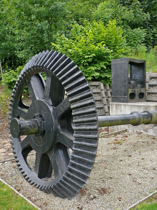 a large wooden clockwheel on some kind of rock