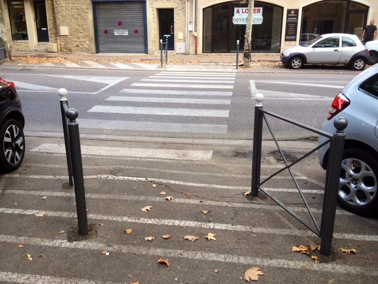 a city street with two parking meters near an intersection