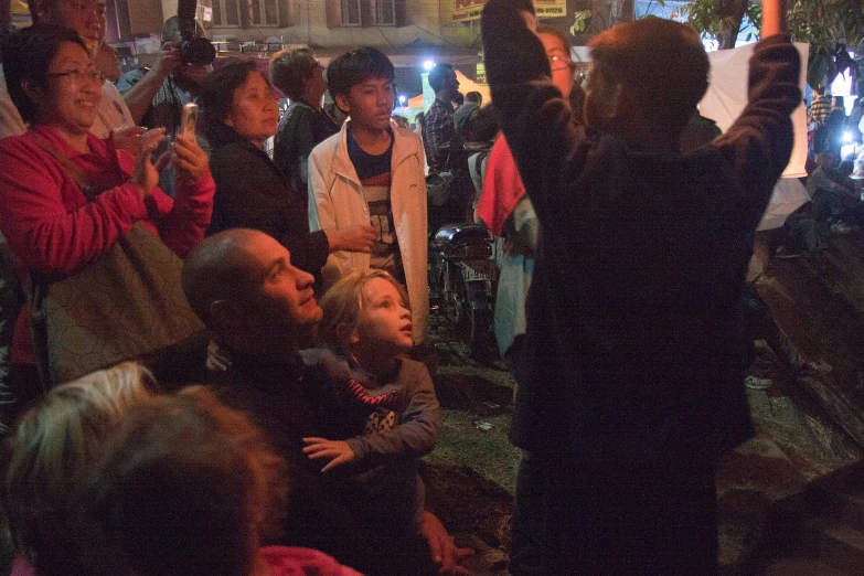 a crowd of people standing outside in front of buildings