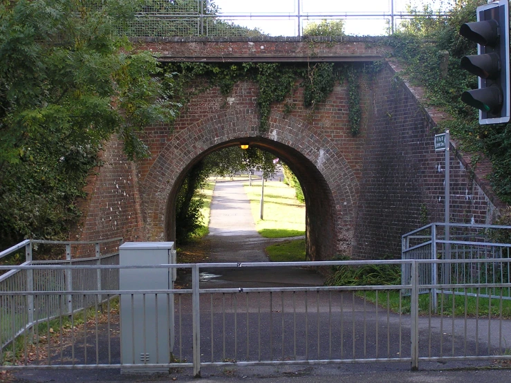 a gate and traffic light at an old brick tunnel