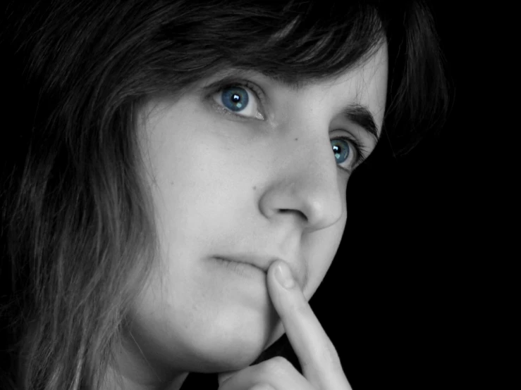 a close - up of a woman with her finger on her lips