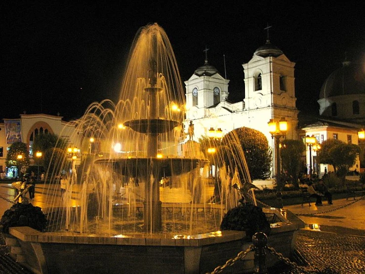 an illuminated fountain in front of a church