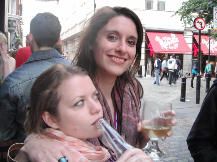 two women are enjoying wine at an outdoor event