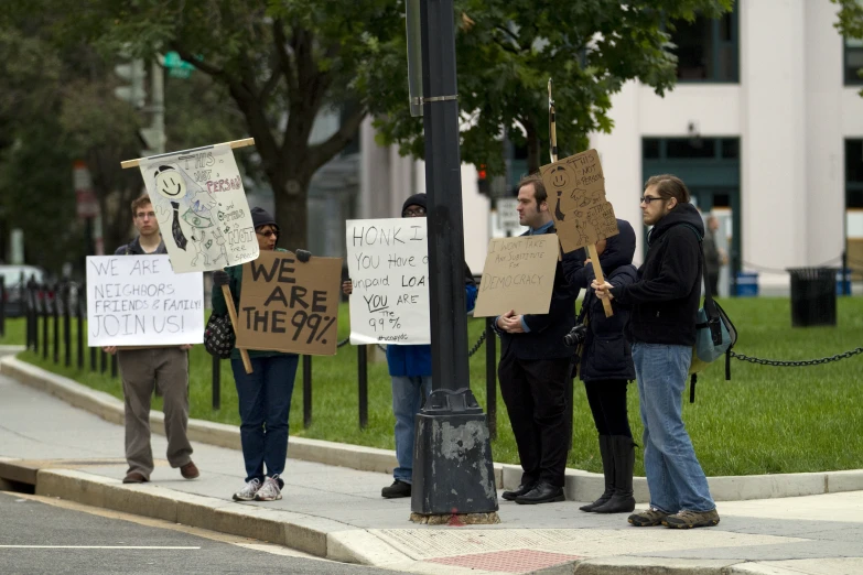 a group of men holding signs on the side of a road