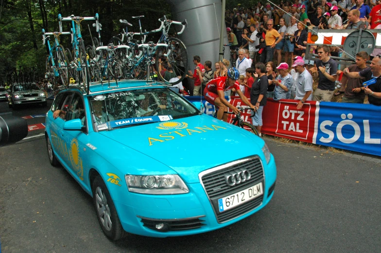 a man riding a car with a bunch of bikes on top of it