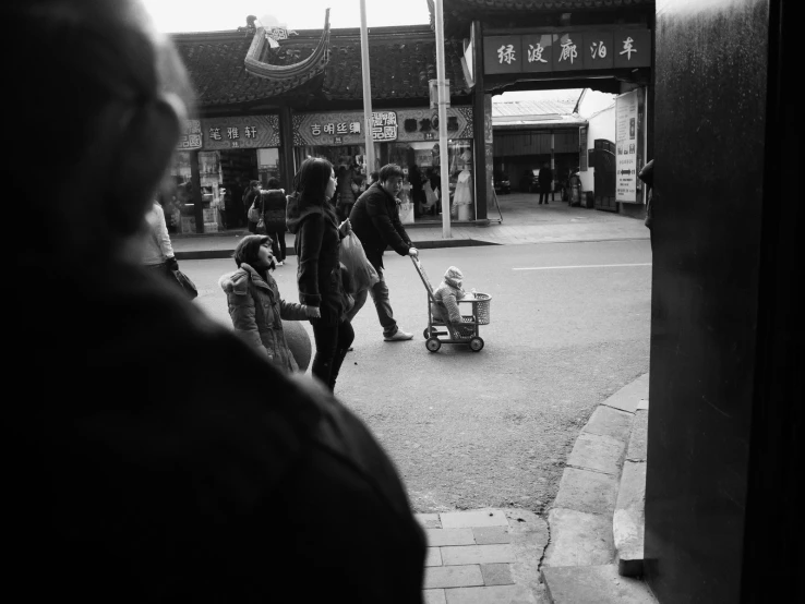 an asian woman with a child walking down the street