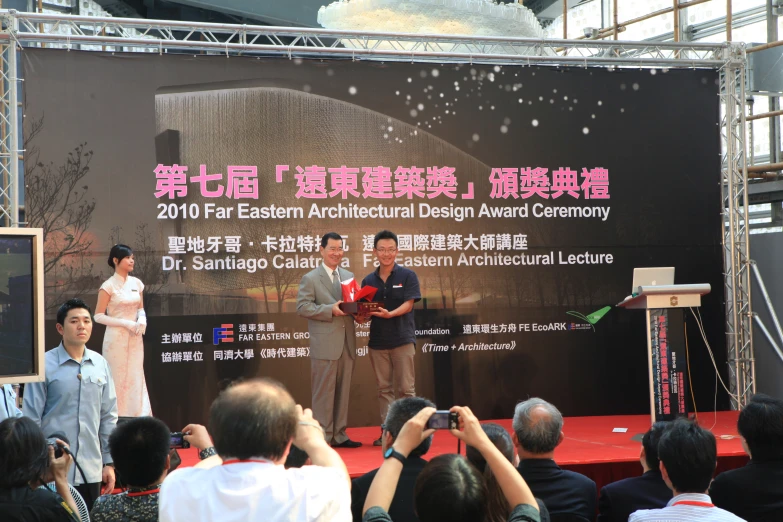 a stage at an asian conference with two people on the podiums