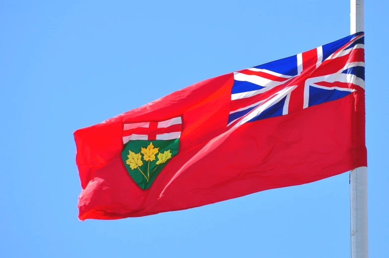 a flag flying in the wind with the flag british and canadian