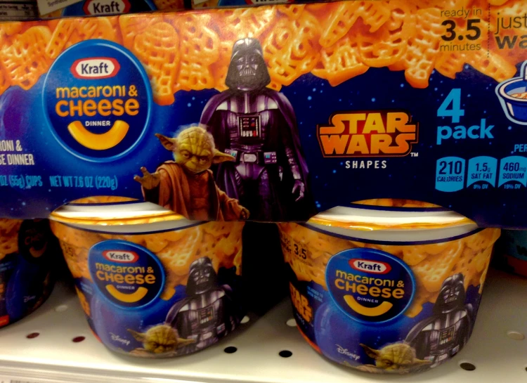 three cups with cereal on them, two in front of the pack of star wars characters, one in the background with cheese