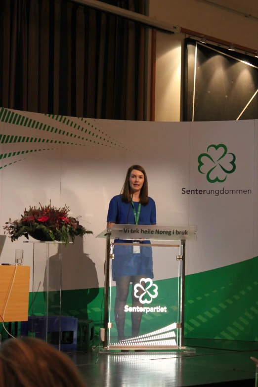 woman giving a speech at podium in front of microphone