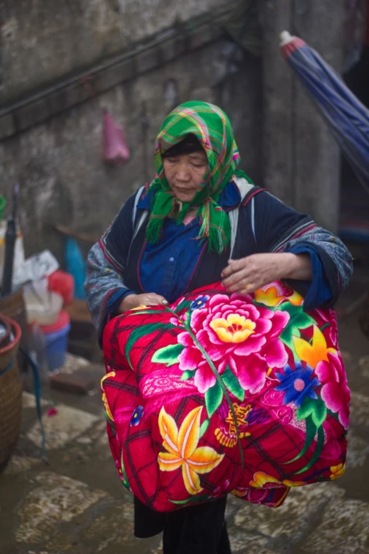 the woman is carrying a large colorful bag