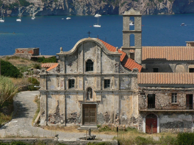 the building has orange tiled roofs and is surrounded by hills