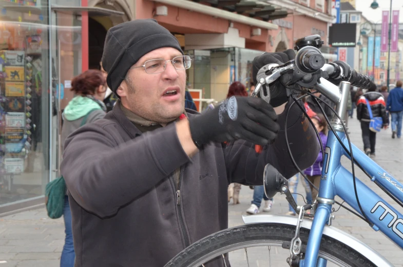 the man is standing by his bike talking on his phone