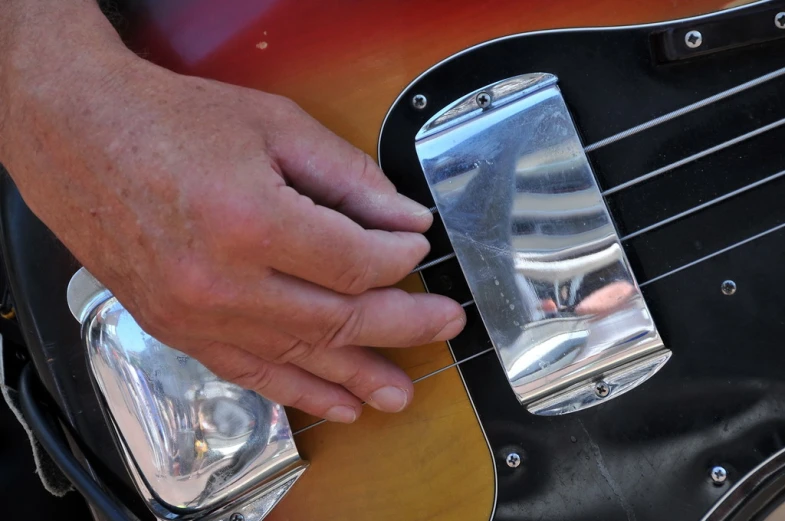 a close up of the hand of a man playing an electric guitar