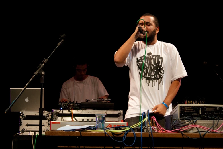 a man on a cell phone standing near keyboards