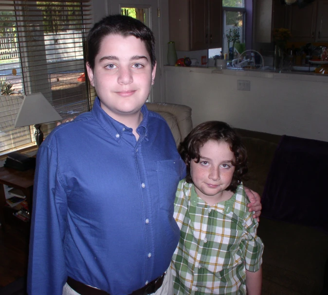 a  with a blue shirt and a  are standing in front of a couch