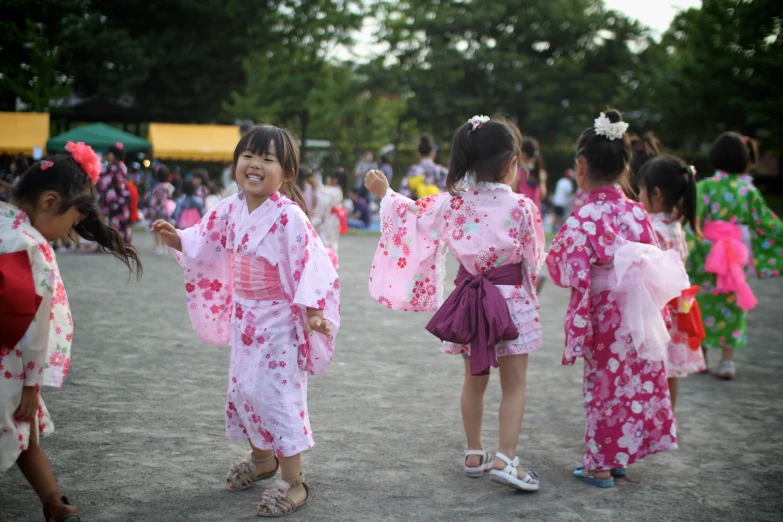 children dressed in kimonos playing with a ball