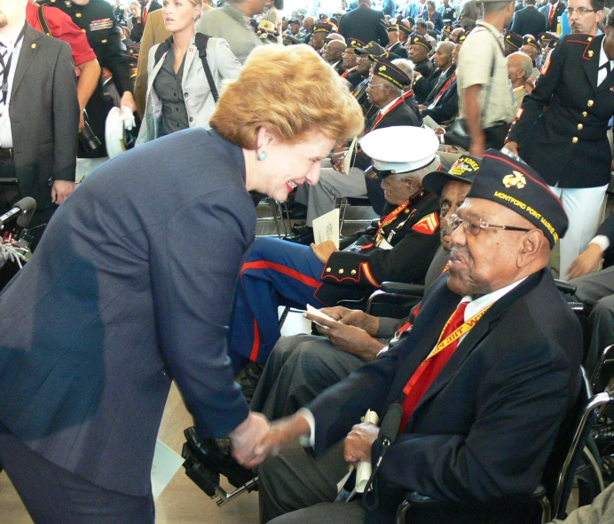 woman in uniform talking to a man on the side of the floor