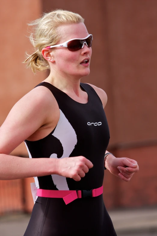 a woman running in a race wearing a black tank top