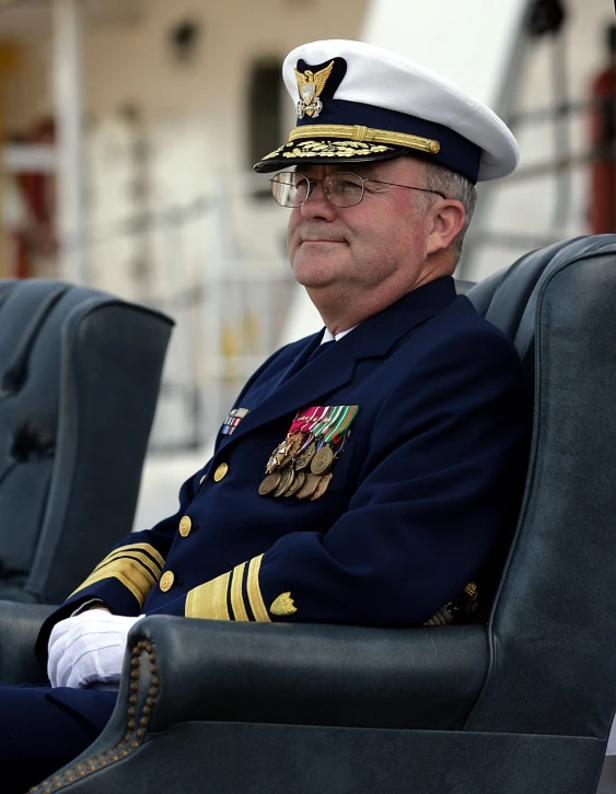 a man in military dress clothes sitting in an open seat