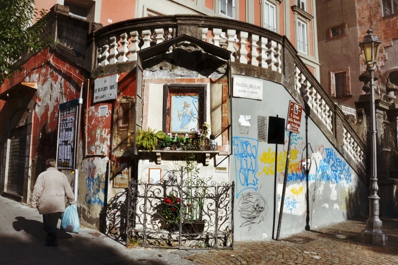 a street corner with graffiti and a woman walking