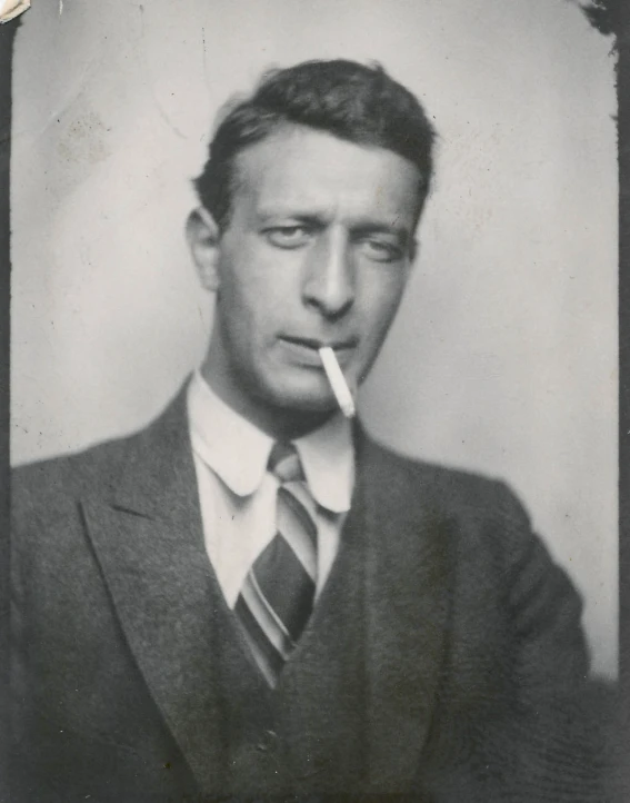 an old pograph of a man smoking in a suit