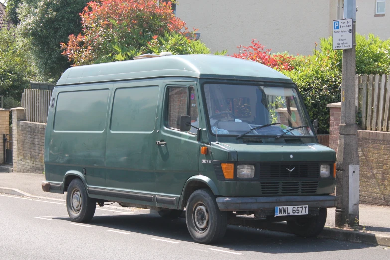 a small blue van parked on the side of the road