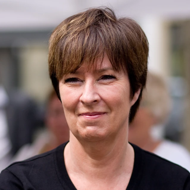 a woman smiling and wearing a black shirt