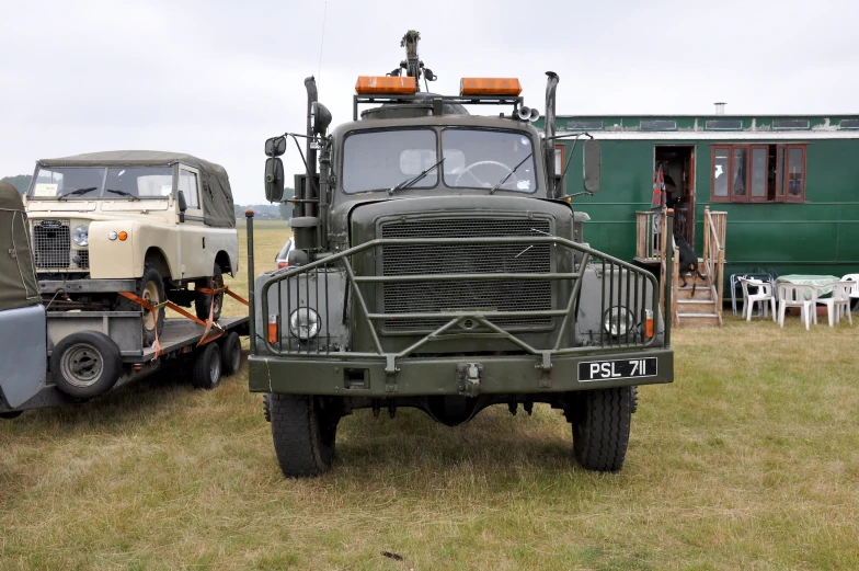 an army vehicle on a flat bed trailer in a field