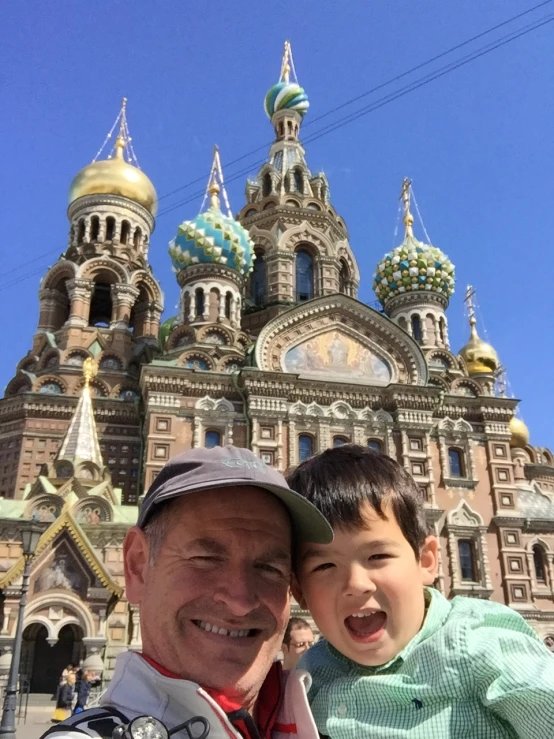 a man and boy smile in front of an old church