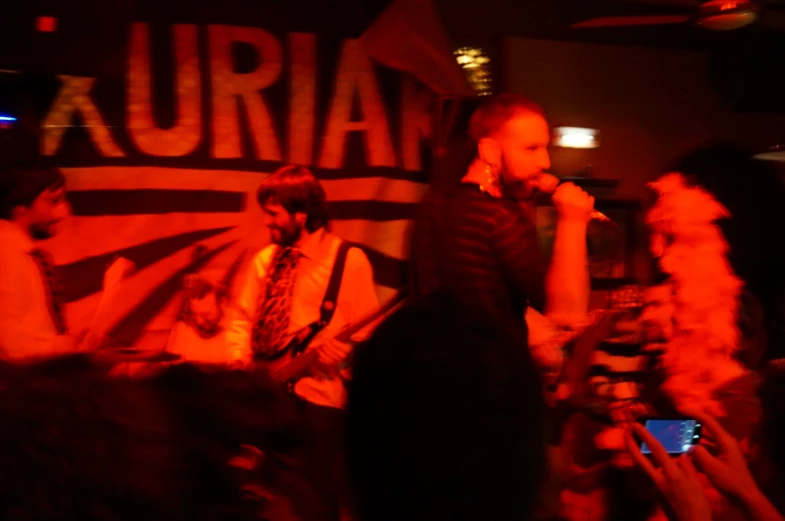 a group of people singing in a dimly lit room