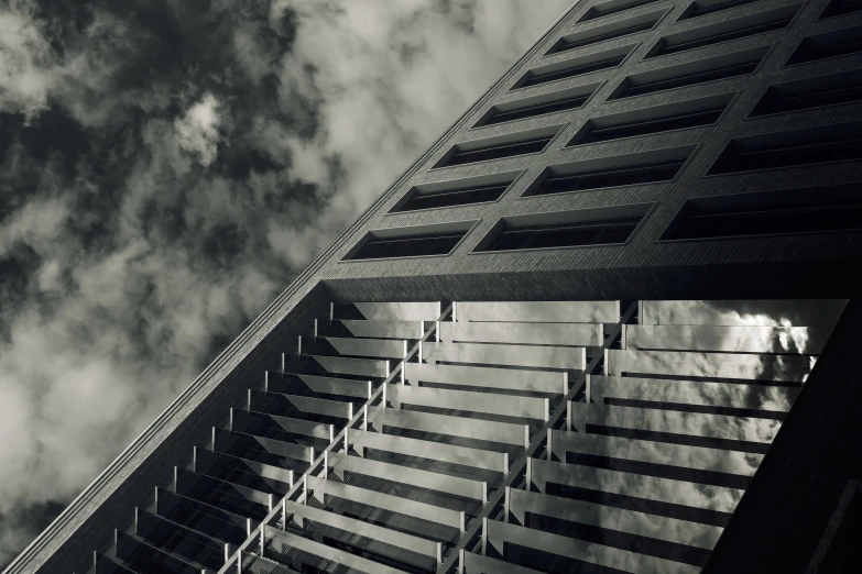 an image of a tall building with some clouds in the background