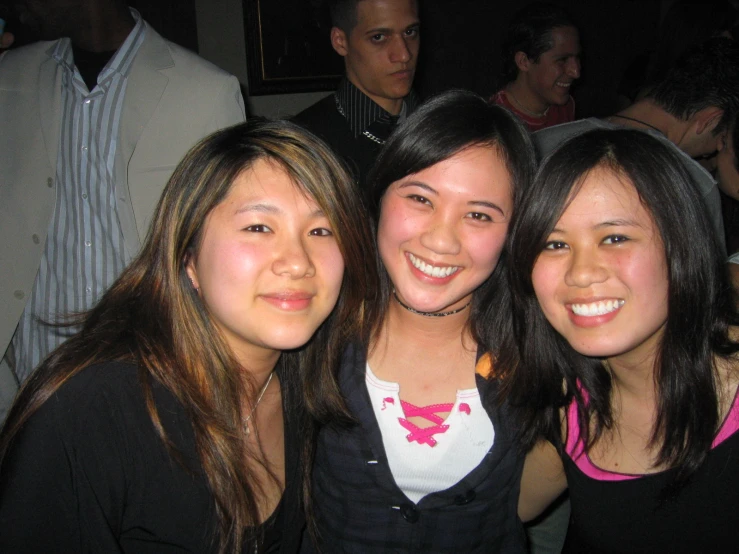 a group of young women standing together in front of a bar