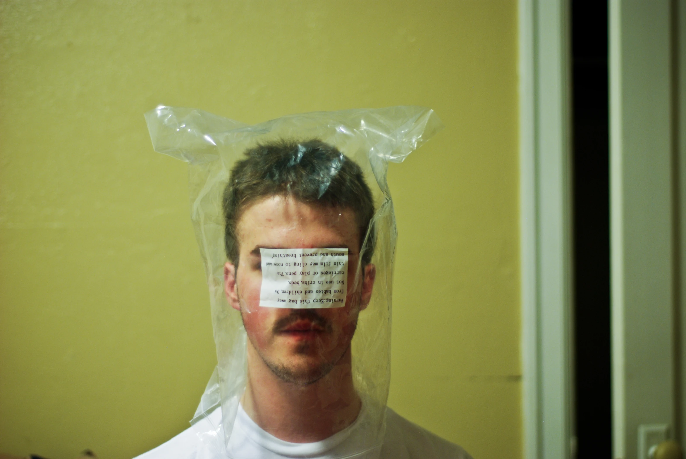 a man is wearing a plastic bag with his face taped