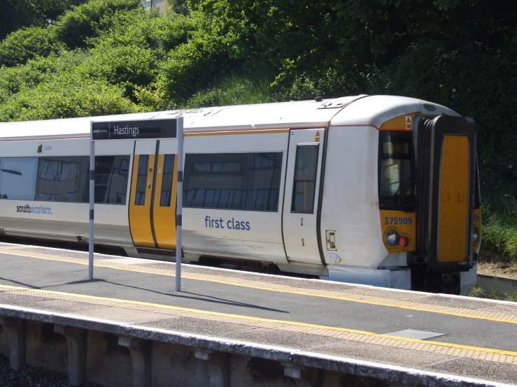 a passenger train sits on the tracks near the station