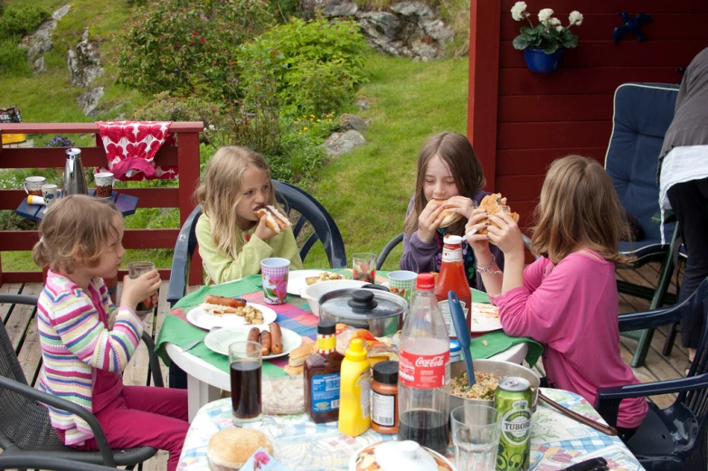 a group of children eat lunch at a table