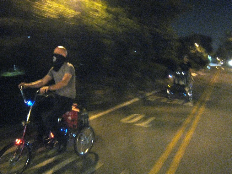 the man is riding the bike on the road with his son