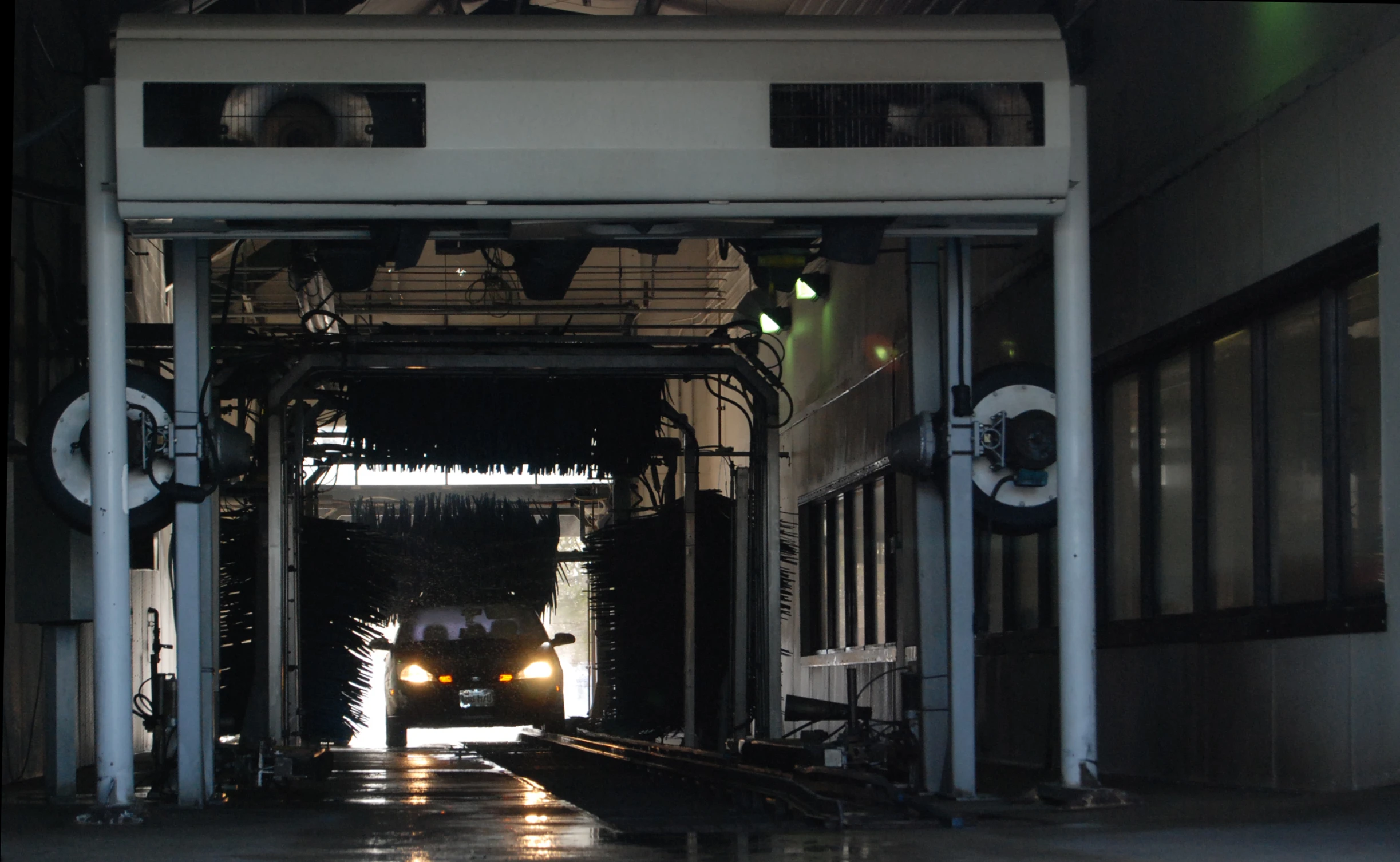 a train traveling down the tracks underneath a train tunnel