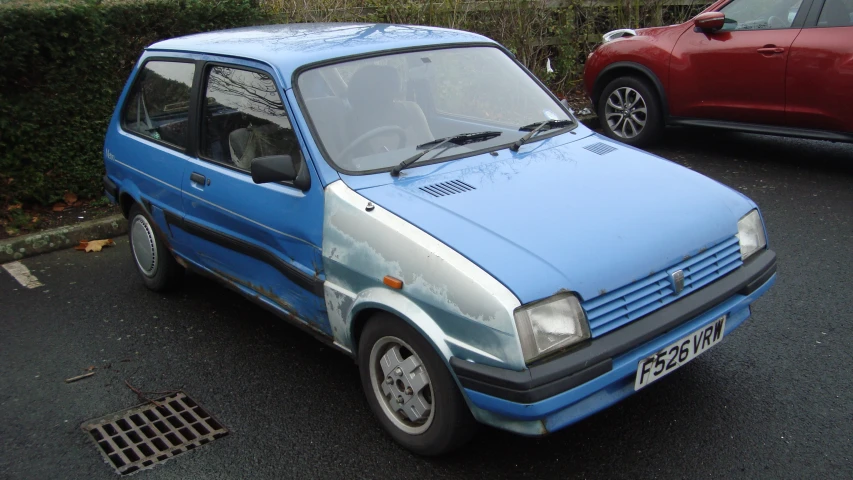 a blue hatchback car parked on the side of a road