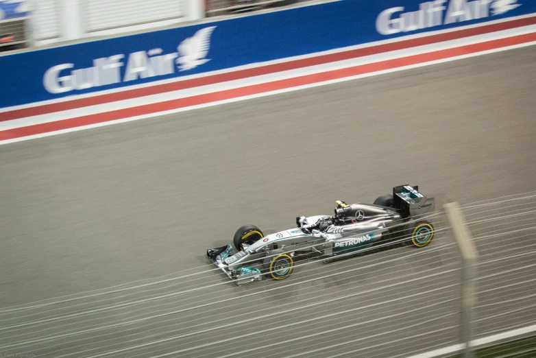 a silver and black racing car is coming around a corner