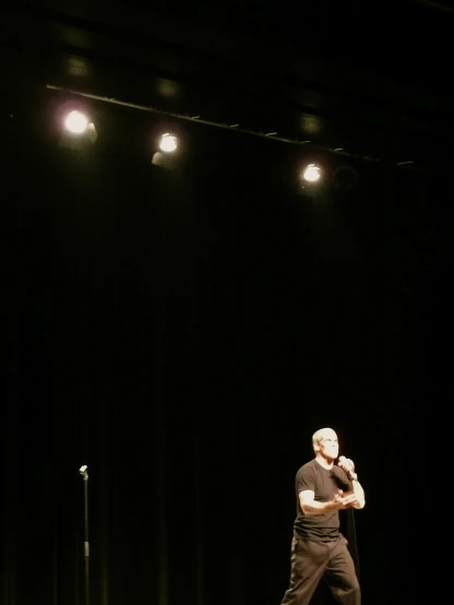 a man with his arm crossed standing on a stage