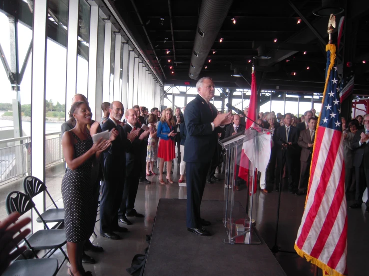 some people standing near a flag and a speaker